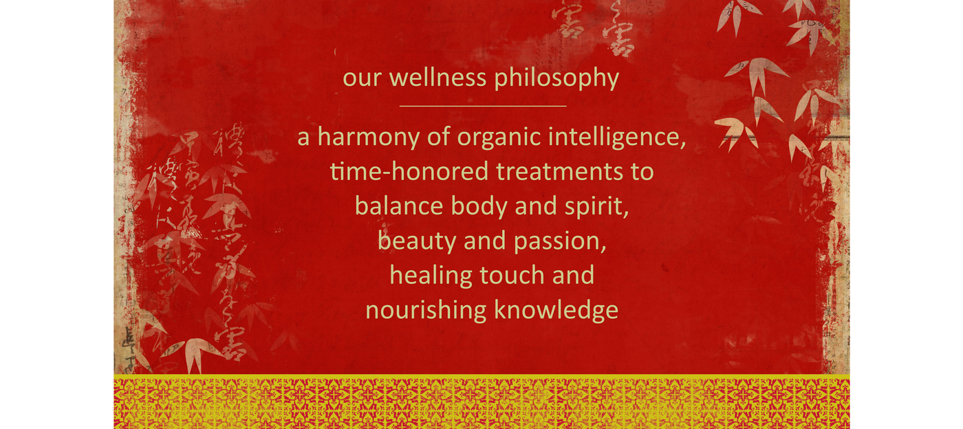 A red background with a gold border and text in the center. The text reads: "Our Wellness Philosophy, A harmony of organic intelligence, time-honored treatments to balance body and spirit, beauty and passion, healing touch and nourishing knowledge."